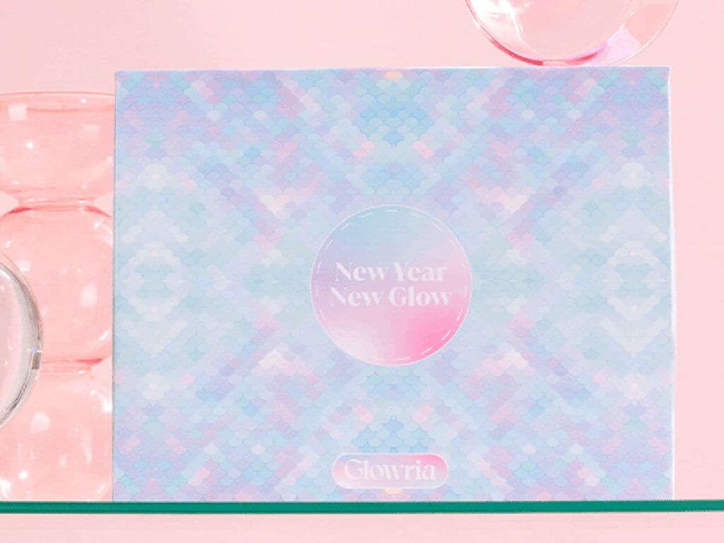 Design du coffret Glowria « New Year, New Glow » avec motif irisé sur fond rose