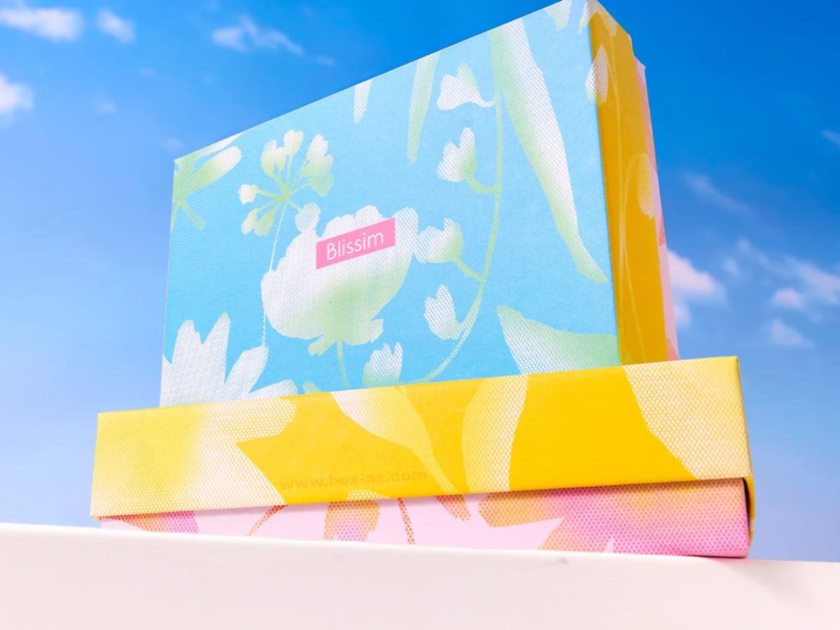 Coffret Blissim édition Spring Boost au design floral printanier photographié sous un ciel bleu