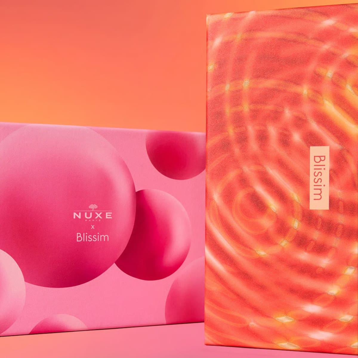 Les deux designs de box proposés ce mois-ci : l’édition Nuxe rose et la box découverte multi-marques orange.