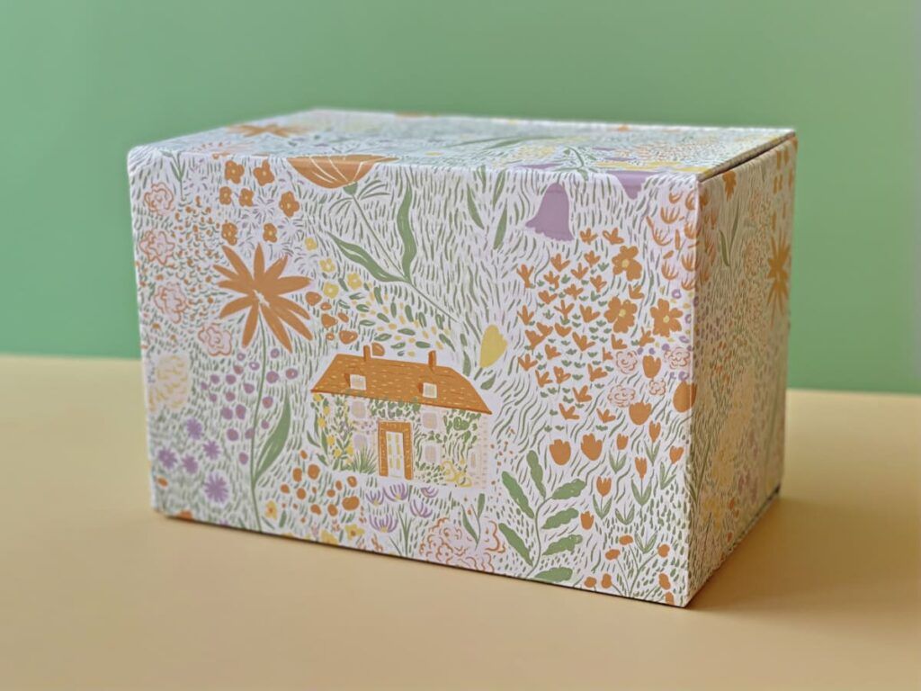 Arrière du coffret My Little Box Jardin Enchanté avec illustration d’un jardin et maison
