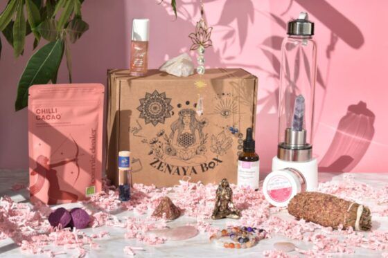 Zenaya Box box bien-être et holistique pour femme, avec cosmétiques, bijoux, pierres énergétiques et accessoires présentés sur fond rose