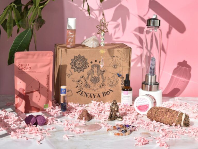 Zenaya Box box bien-être et holistique pour femme, avec cosmétiques, bijoux, pierres énergétiques et accessoires présentés sur fond rose