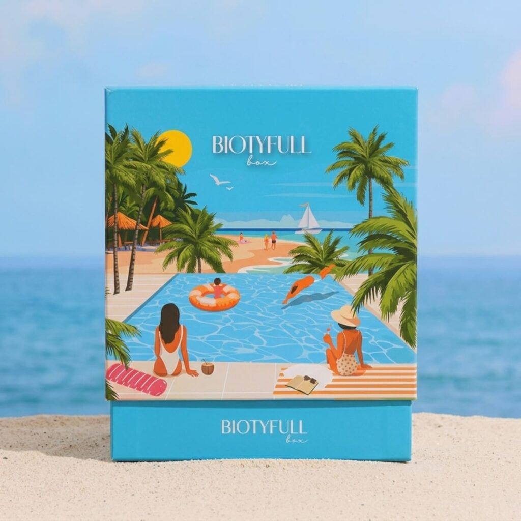 Design de la box « Été au Bord de l’Eau » de Biotyfull Box avec décor plage et palmiers