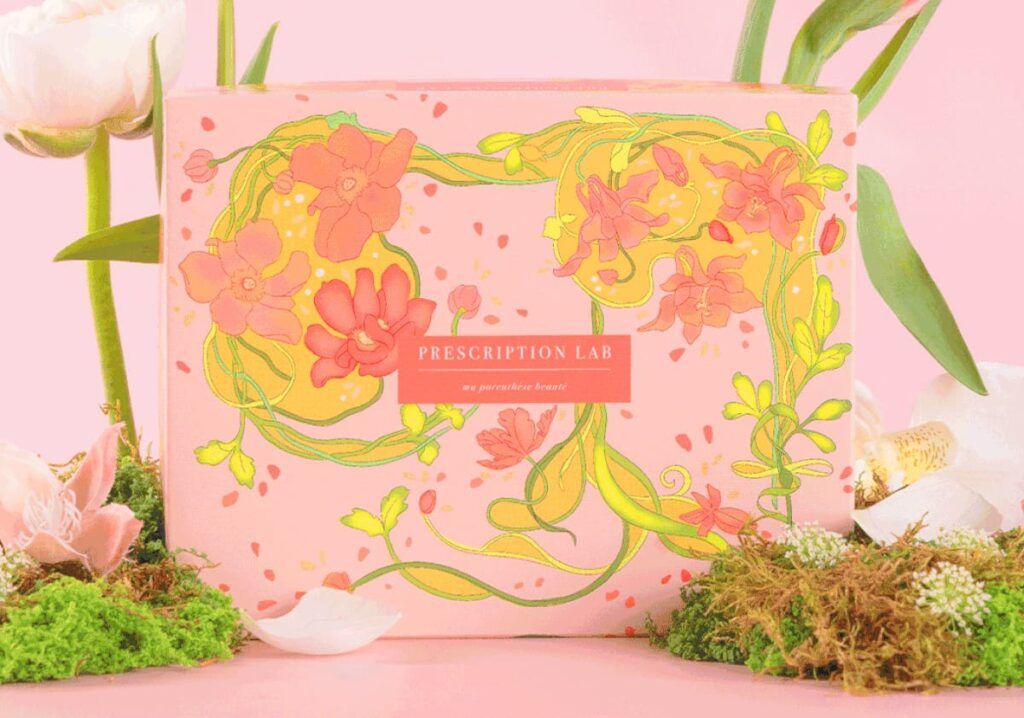 Design de la box Potion Enchanteresse de Prescription Lab avec illustration florale colorée sur fond rose