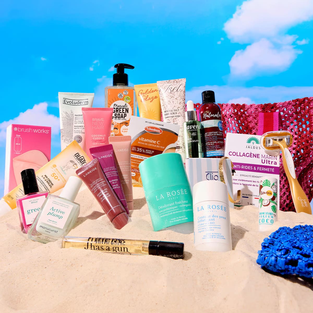 Spoiler complet de la box Blissim juillet-août 2026 avec les produits beauté dévoilés sur une plage de sable et les paniers d'été rose et bleu.