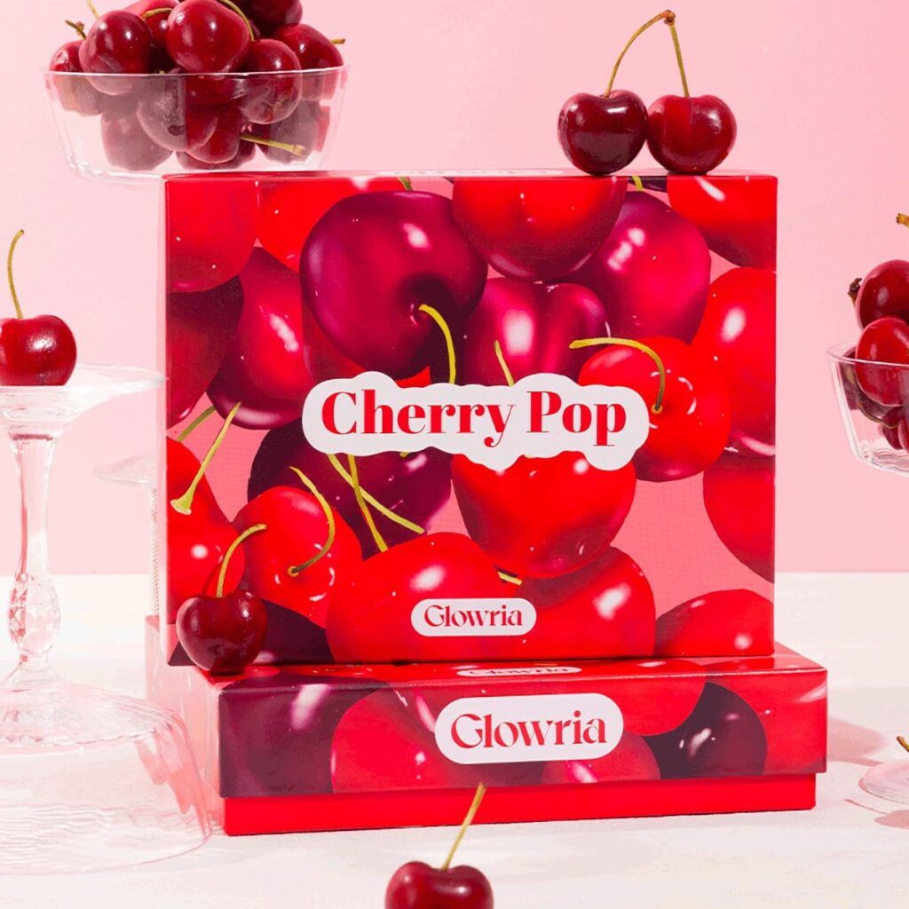 Design de la box Cherry Pop de Glowria illustrée de cerises rouges sur fond rose pastel