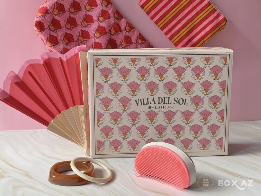 Accessoires lifestyle de l’édition Villa del Sol avec éventail rose, duo de pochettes, joncs solaires et brosse nettoyante