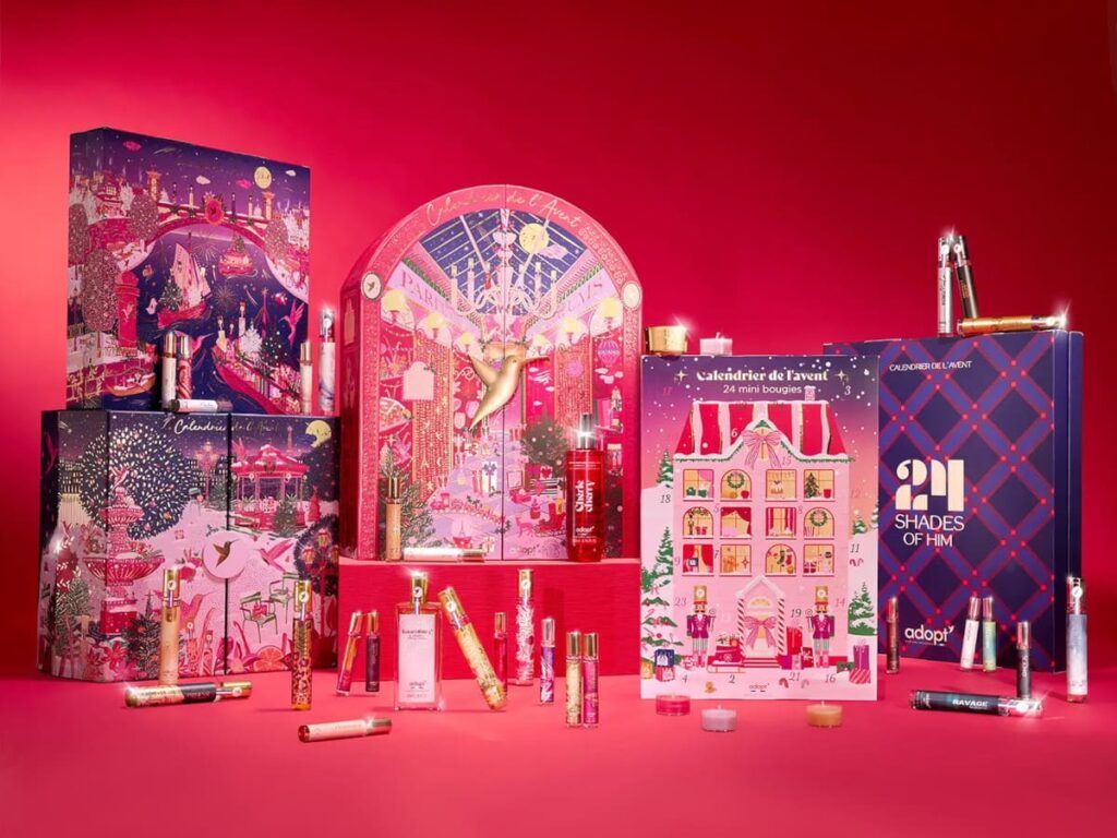 Les 5 calendriers de l'Avent Adopt sur fond rouge, avec 3 versions avec parfums pour femme, une version bougie et une pour homme.