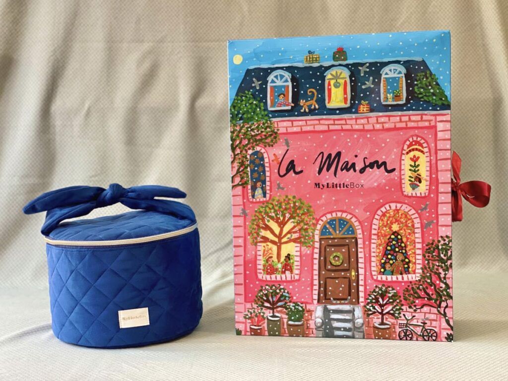 Le vanity premium Oracle de l’Hiver en tissu bleu matelassé à côté du calendrier illustré La Maison My Little Box aux façades roses