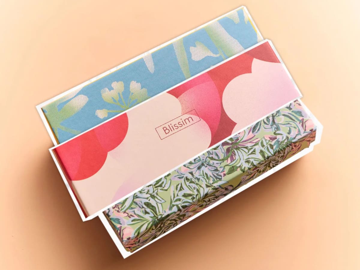 Trois anciens packagings Blissim aux motifs floraux et colorés, réutilisés pour l'édition « Beauté partagée »